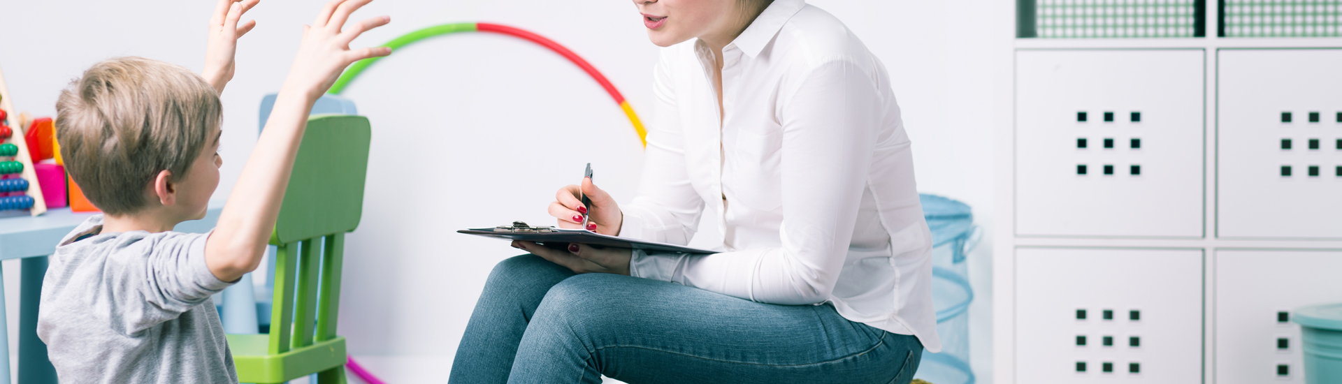 Small boy during session with young woman psychologist, panorama.